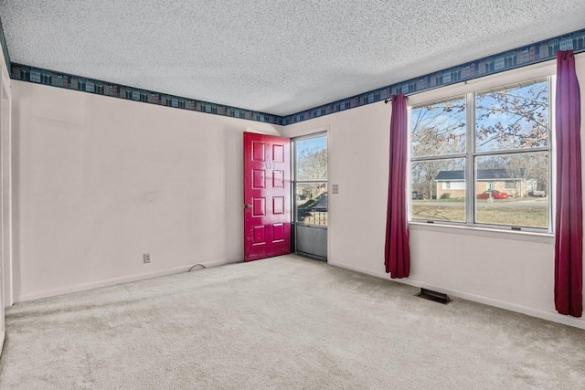 spare room featuring light carpet and plenty of natural light