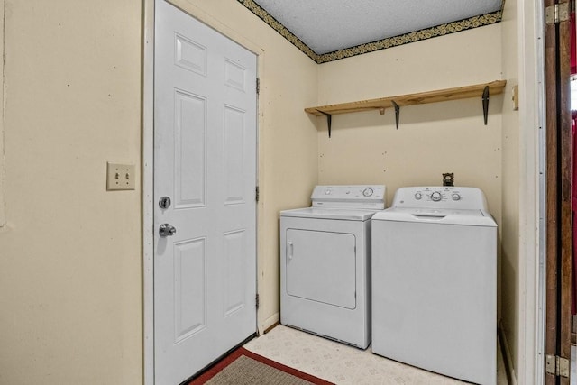 laundry room with separate washer and dryer and a textured ceiling