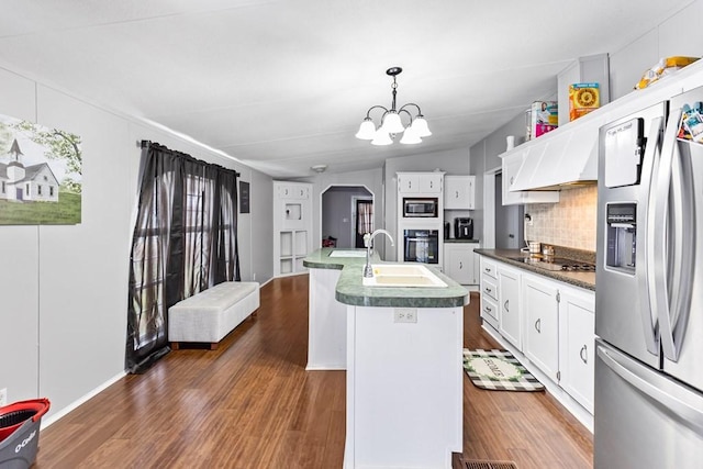 kitchen with black appliances, sink, vaulted ceiling, an island with sink, and decorative light fixtures