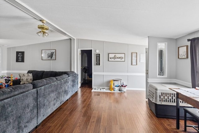 living room with dark hardwood / wood-style flooring and vaulted ceiling