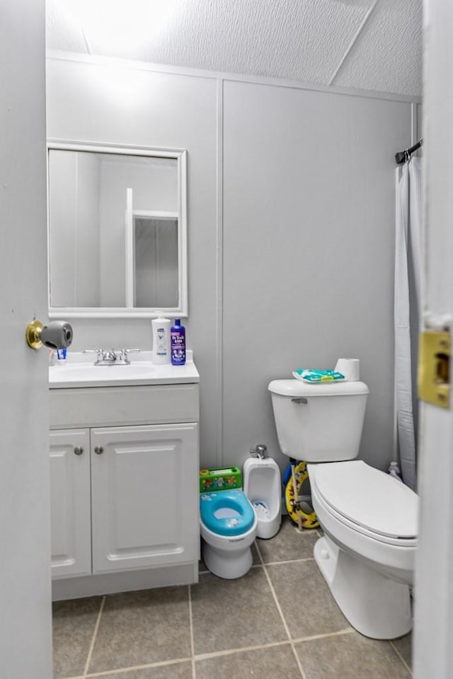 bathroom featuring tile patterned floors, vanity, and toilet