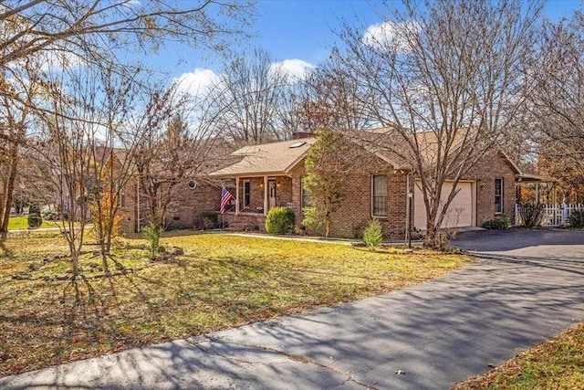 ranch-style home with a front yard, a garage, and covered porch