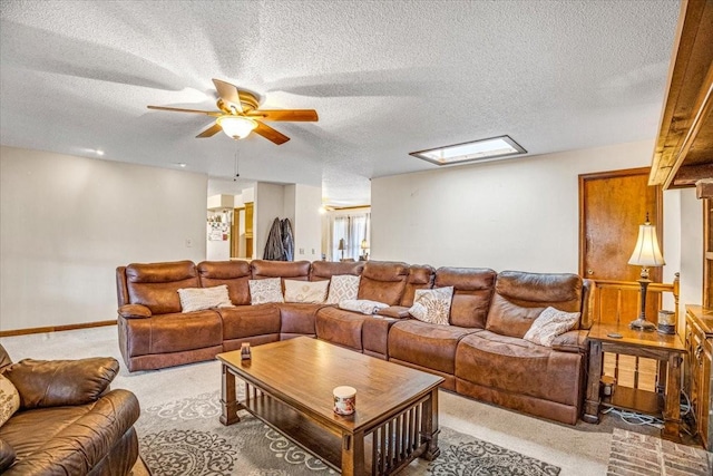 carpeted living room with ceiling fan and a textured ceiling