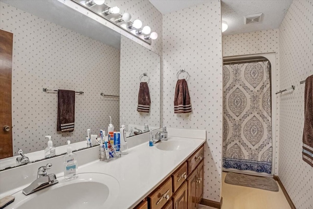 bathroom with vanity, curtained shower, and a textured ceiling