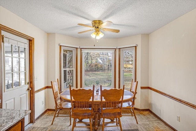 dining area with ceiling fan and a textured ceiling