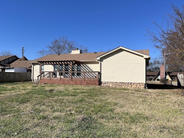 back of house featuring a lawn and a deck