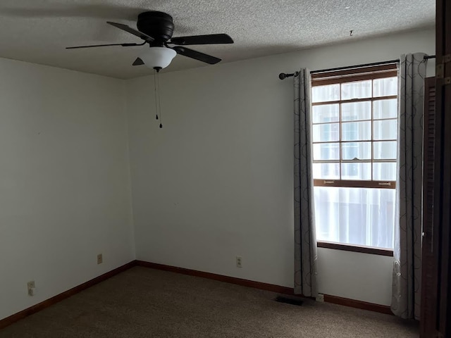 spare room with ceiling fan, carpet floors, and a textured ceiling