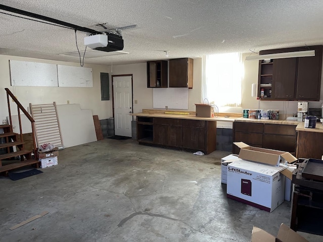 garage featuring a workshop area, electric panel, and a garage door opener