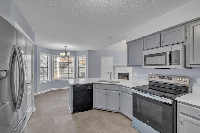 kitchen featuring sink, hanging light fixtures, gray cabinets, appliances with stainless steel finishes, and a chandelier