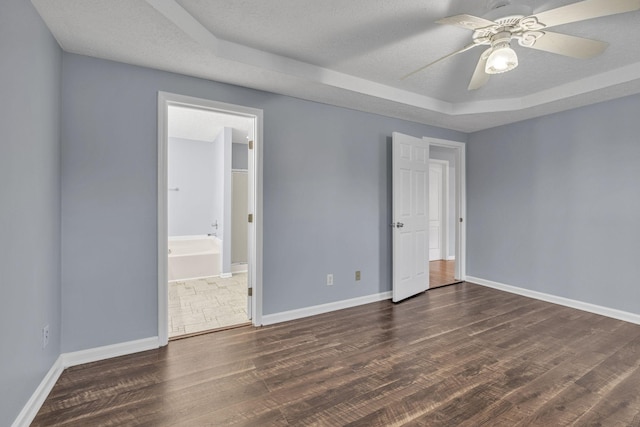 unfurnished bedroom featuring a textured ceiling, ceiling fan, dark wood-type flooring, and ensuite bath