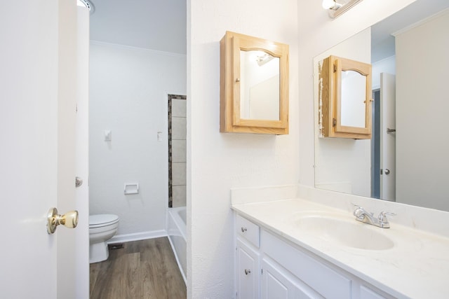 full bathroom with hardwood / wood-style floors, vanity, shower / bathing tub combination, crown molding, and toilet