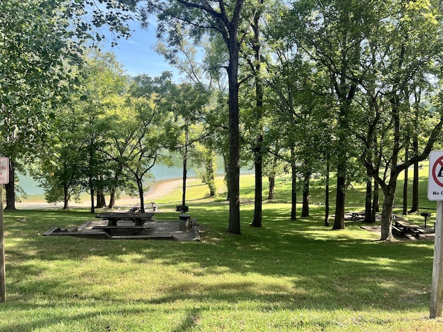 surrounding community featuring a water view and a yard