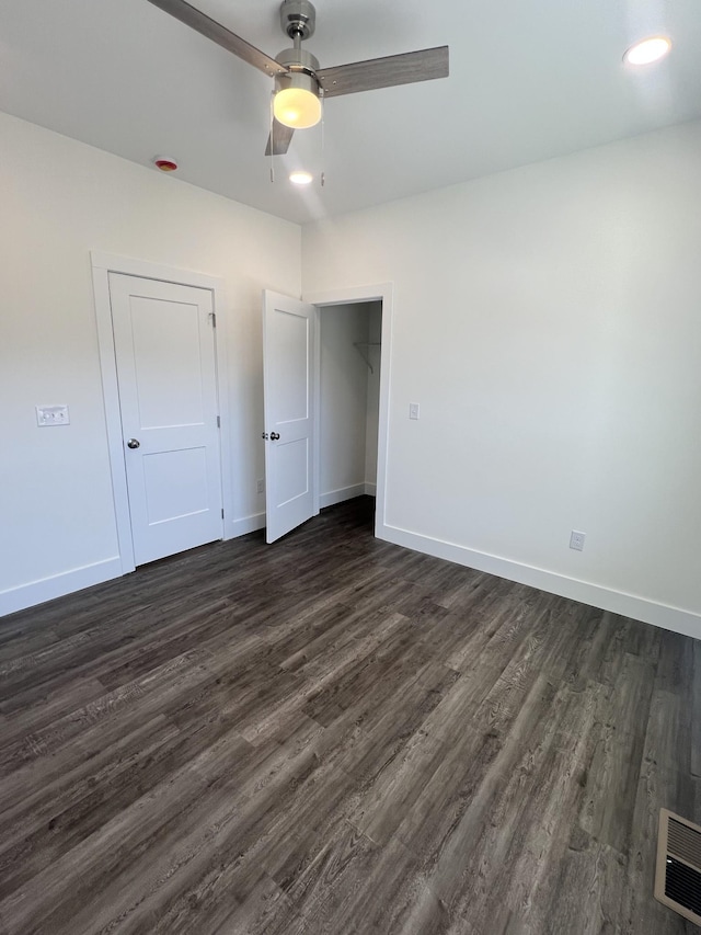 unfurnished bedroom featuring dark wood-type flooring and ceiling fan