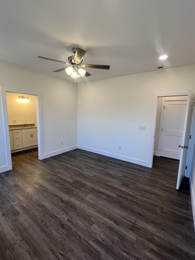 unfurnished bedroom featuring dark wood-type flooring, connected bathroom, and ceiling fan