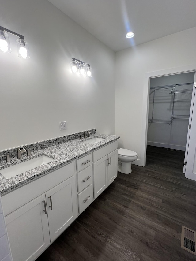 bathroom with vanity, hardwood / wood-style flooring, and toilet