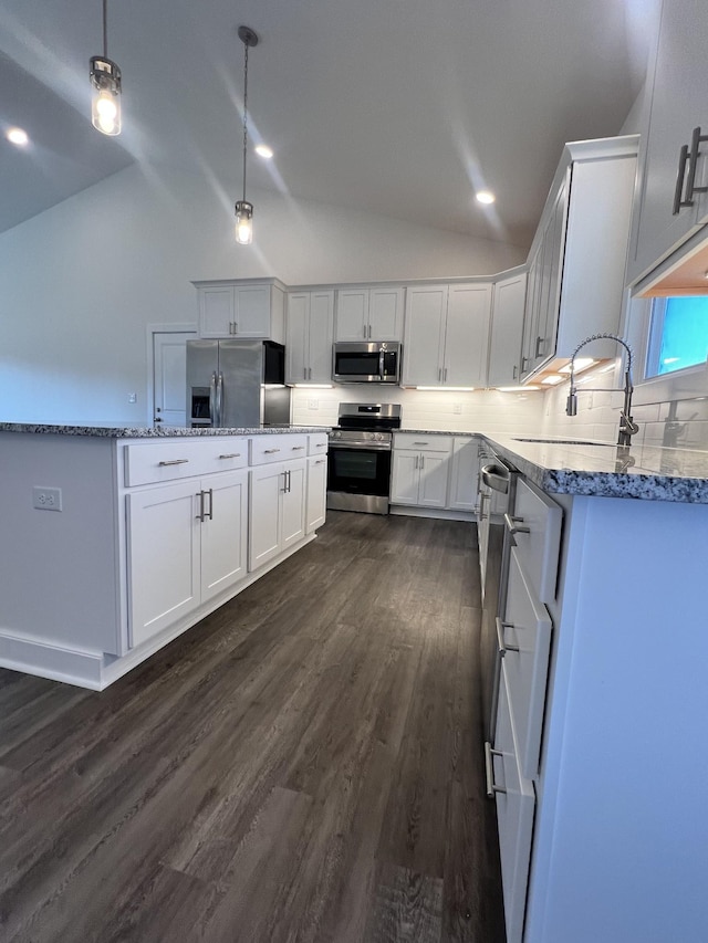 kitchen with sink, hanging light fixtures, stainless steel appliances, decorative backsplash, and white cabinets