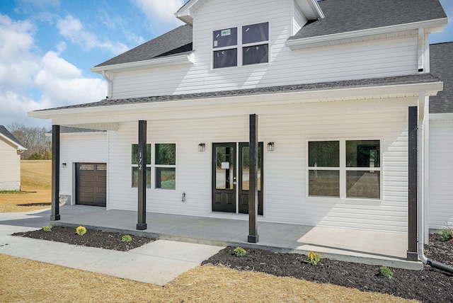 view of front of home featuring a porch, driveway, and roof with shingles