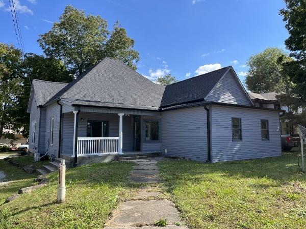 view of front of property with covered porch and a front lawn