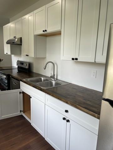 kitchen featuring appliances with stainless steel finishes, white cabinetry, and sink