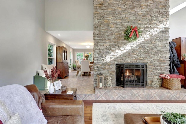 living room featuring a large fireplace, a high ceiling, and hardwood / wood-style flooring