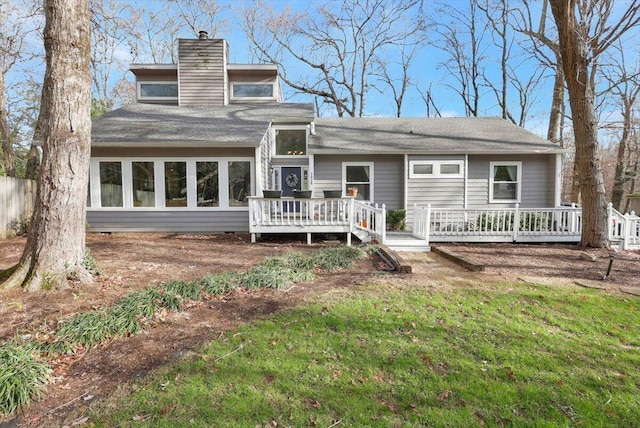 rear view of house featuring a lawn and a wooden deck