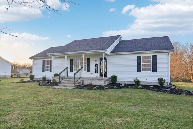 ranch-style home featuring covered porch and a yard