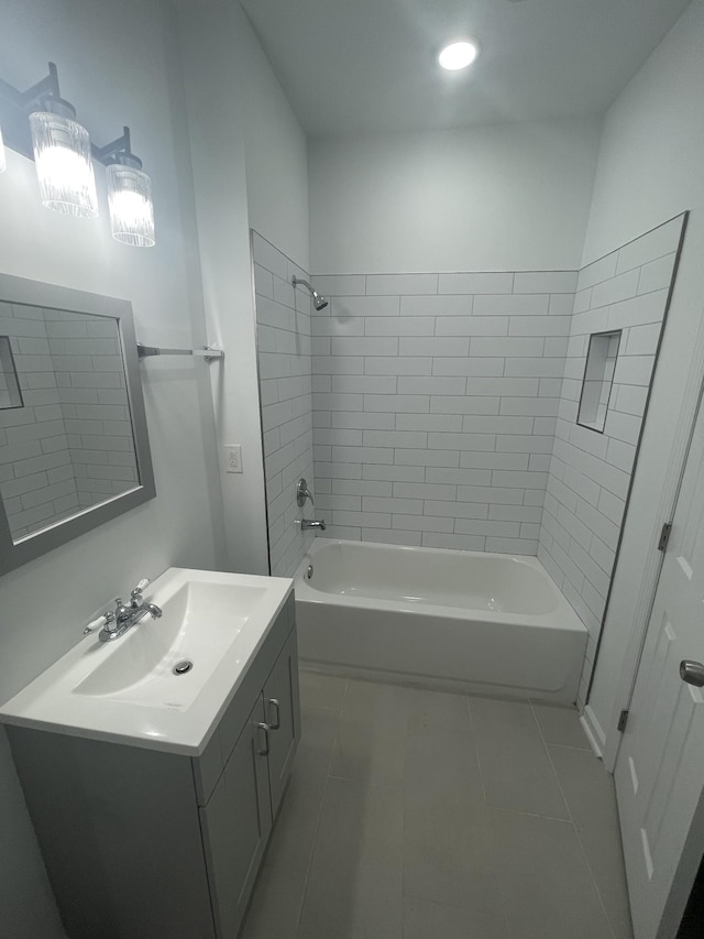 bathroom with tile patterned flooring, tiled shower / bath combo, and vanity