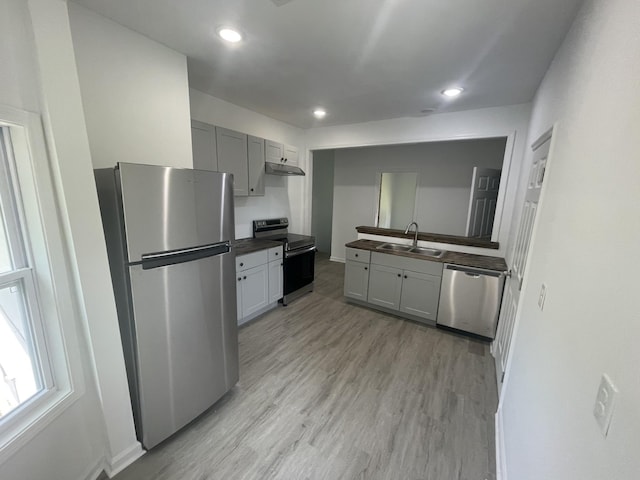 kitchen featuring gray cabinetry, sink, stainless steel appliances, and light wood-type flooring