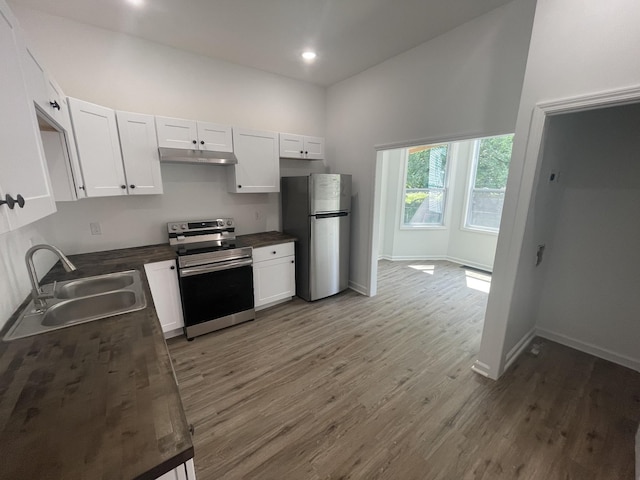 kitchen with dark wood-type flooring, white cabinetry, sink, and stainless steel appliances