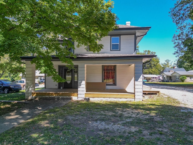 view of front of house with covered porch and a front yard