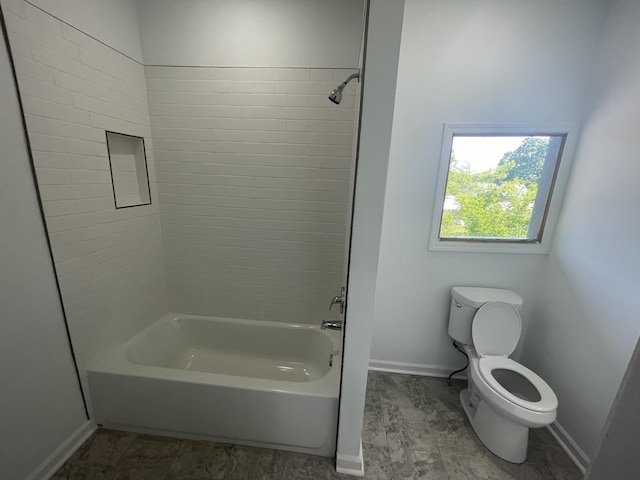 bathroom featuring wood-type flooring, toilet, and tiled shower / bath