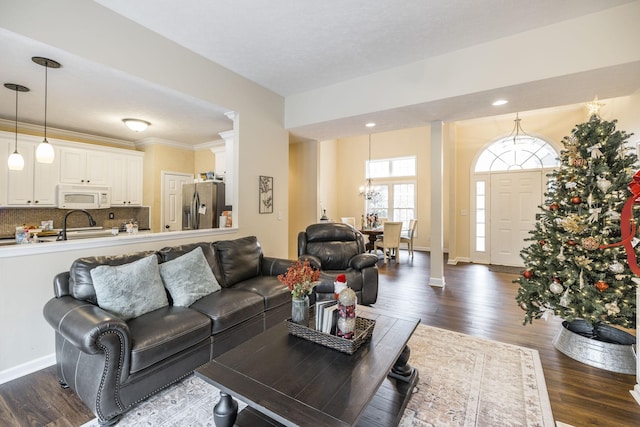 living room with dark hardwood / wood-style flooring, a chandelier, a textured ceiling, and ornamental molding