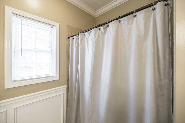 bathroom with ornamental molding and walk in shower