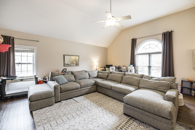 living room featuring ceiling fan, dark wood-type flooring, a wealth of natural light, and vaulted ceiling