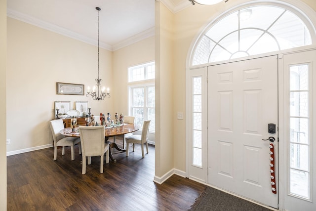 foyer featuring dark hardwood / wood-style floors, crown molding, and a chandelier