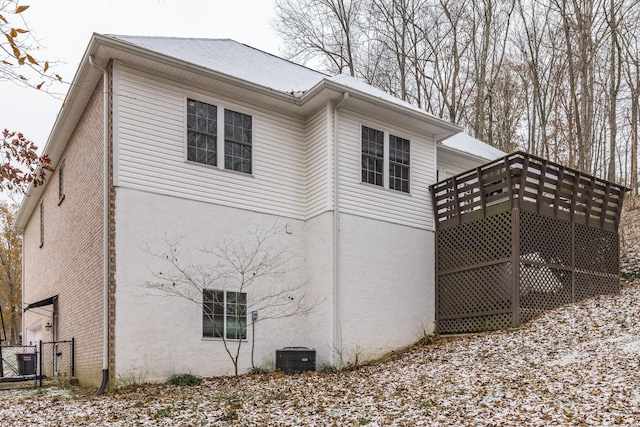 view of side of property with a deck and central AC