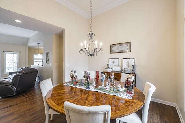 dining area with dark hardwood / wood-style flooring, lofted ceiling, crown molding, and an inviting chandelier