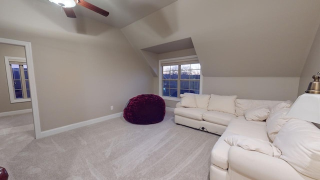 living room featuring ceiling fan, light carpet, and vaulted ceiling