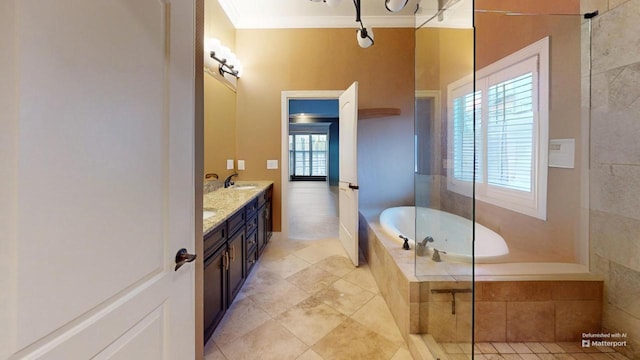 bathroom with vanity, crown molding, and tiled tub