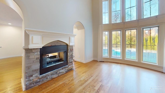 living room with a multi sided fireplace and light hardwood / wood-style flooring