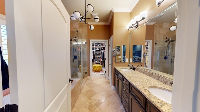 bathroom with an inviting chandelier, tile patterned floors, crown molding, a shower with door, and vanity