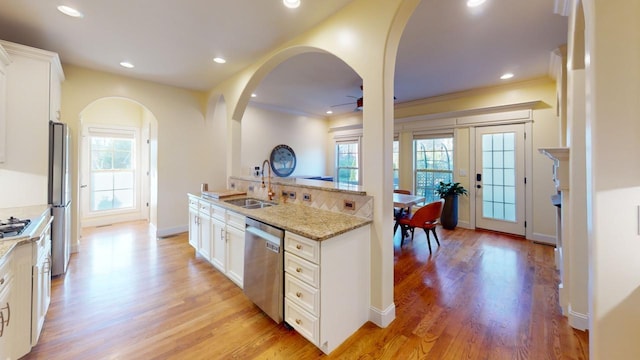 kitchen with white cabinetry, sink, light stone counters, and appliances with stainless steel finishes