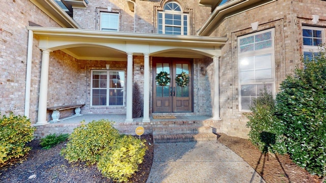 view of exterior entry featuring covered porch