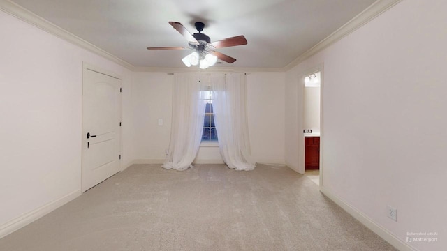 carpeted empty room with ceiling fan and ornamental molding