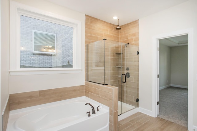 bathroom featuring shower with separate bathtub and hardwood / wood-style flooring