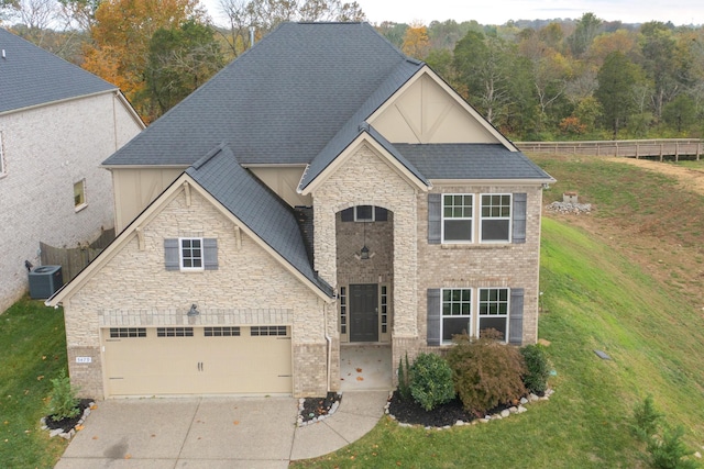 view of front facade with a garage, central air condition unit, and a front yard