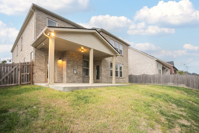 back of house with a yard and a patio