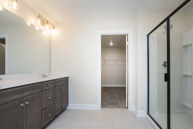 bathroom featuring tile patterned flooring, vanity, and walk in shower