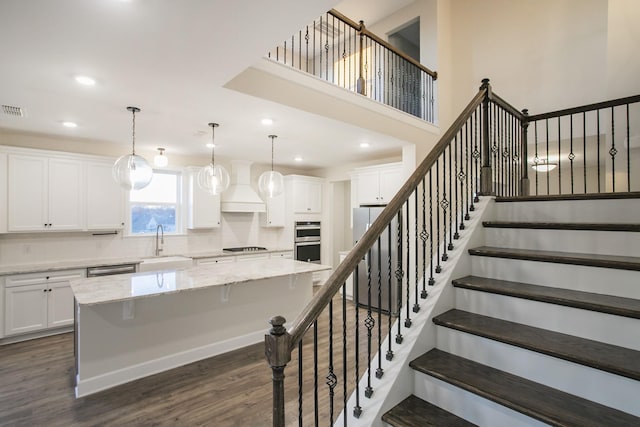 stairs with wood-type flooring and sink