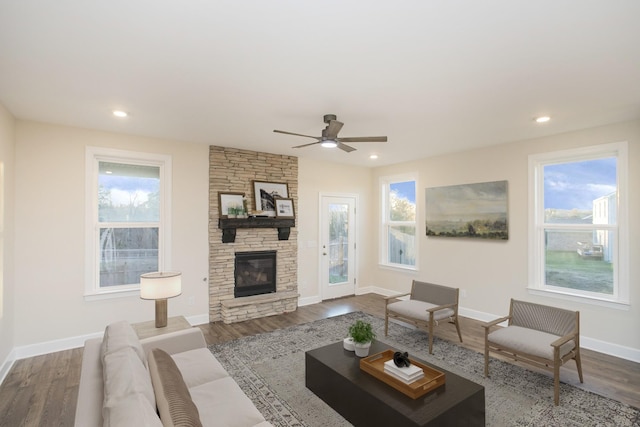 living room with plenty of natural light, a fireplace, dark wood-type flooring, and ceiling fan